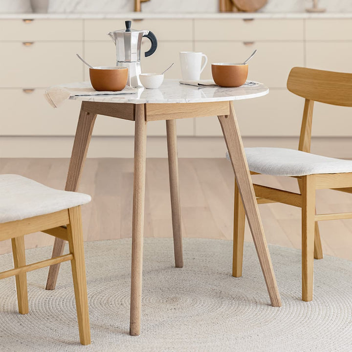 Calypso Cafe Table with marble top and wood legs in a cozy breakfast nook