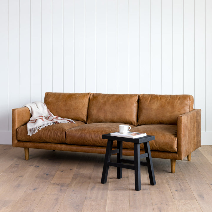 Chambers Leather Sofa in aged tan leather with sheepskin throw in industrial loft interior