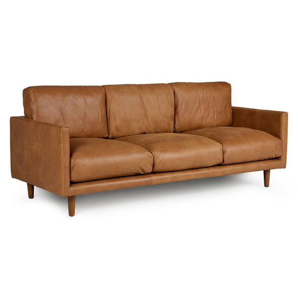 Chambers Leather Sofa in aged tan leather with sheepskin throw in industrial loft interior