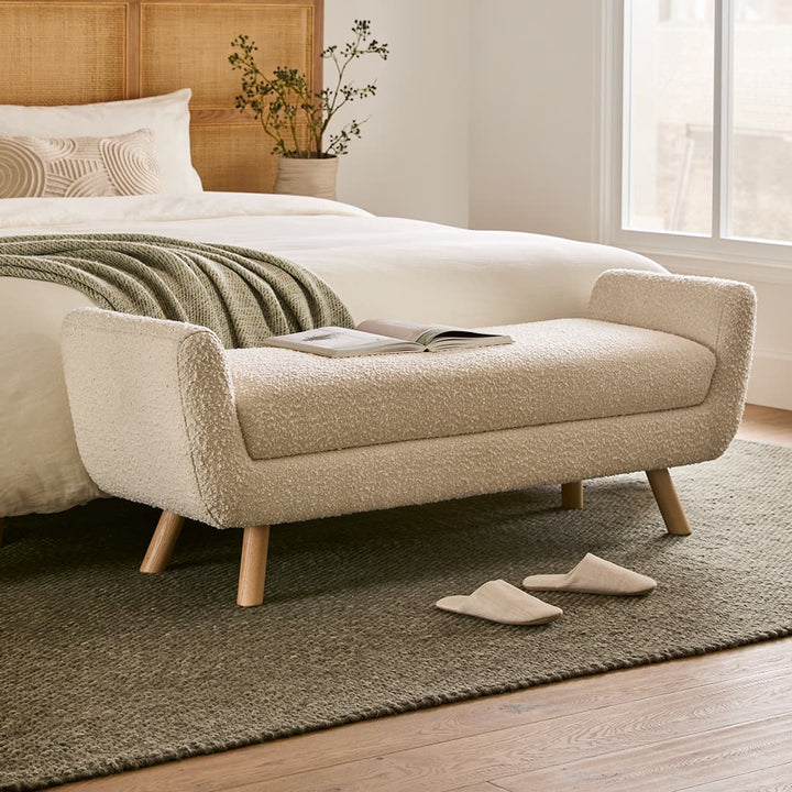 Kebne Bench with bouclé upholstery and ash wood legs in a retro-modern living room