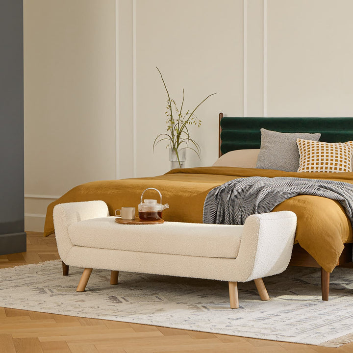 Kebne Bench with bouclé upholstery and ash wood legs in a retro-modern living room