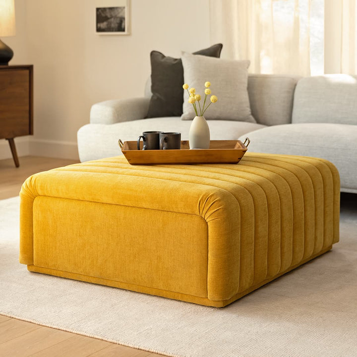 Kiruna Ottoman in a mid-century modern living room with channel-tufted upholstery and wooden legs