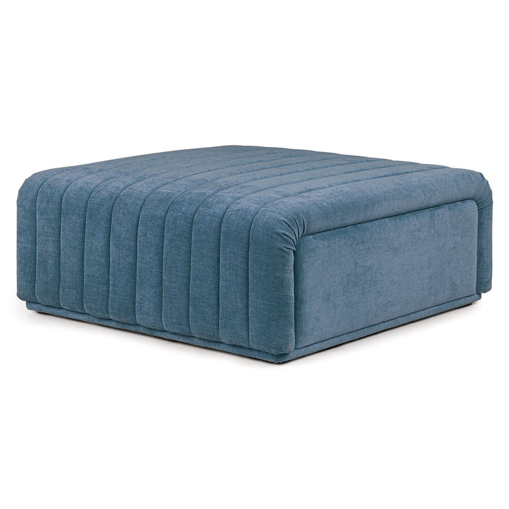Kiruna Ottoman in a mid-century modern living room with channel-tufted upholstery and wooden legs