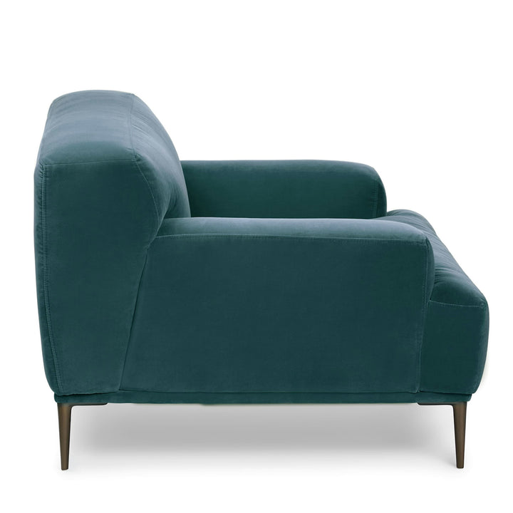 Lumina Velvet Lounge Chair in emerald velvet with titanium legs, showcasing draped-leg lounging posture
