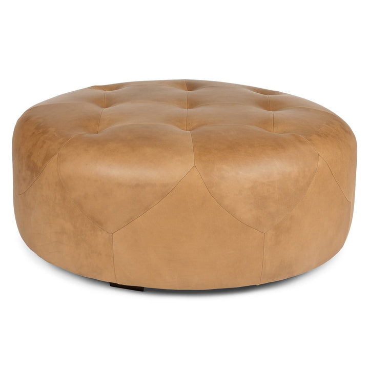 Mohn Leather Ottoman in a modern living room as a tufted leather footrest and coffee table