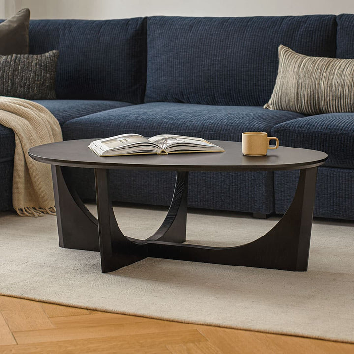 NORDI Coffee Table with sculpted base and natural wood grain in a modern living room