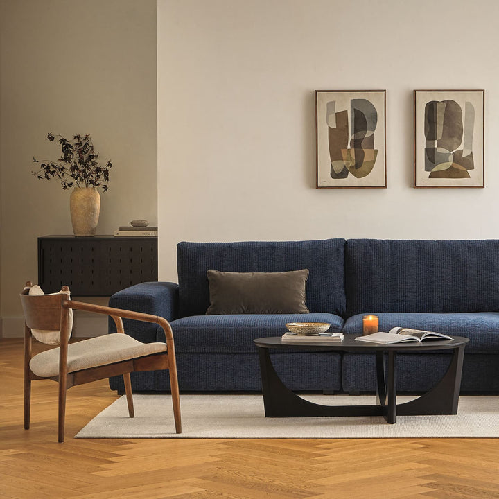 NORDI Coffee Table with sculpted base and natural wood grain in a modern living room
