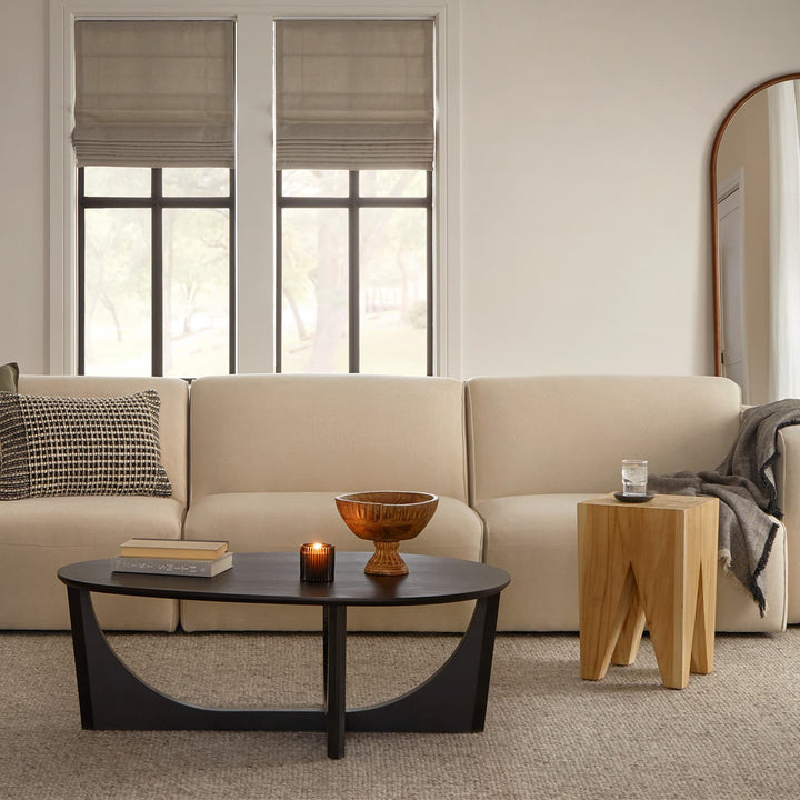 NORDI Coffee Table with sculpted base and natural wood grain in a modern living room