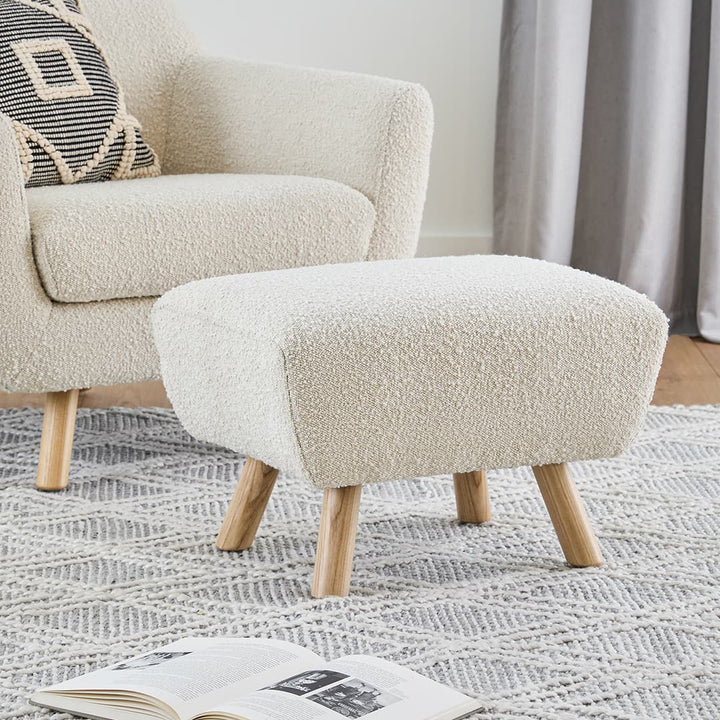 Polnatt Ottoman with bouclé upholstery and wood legs in a Scandinavian-style living room