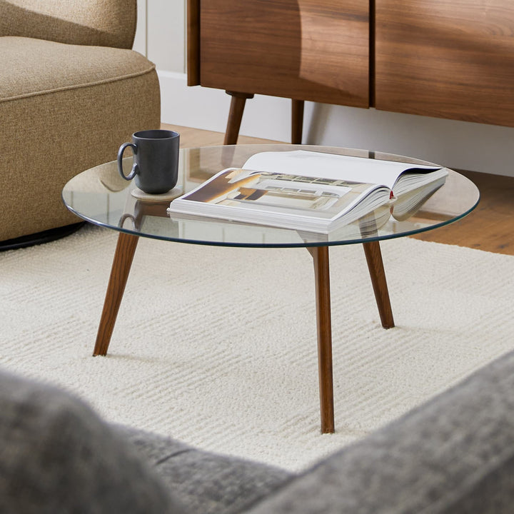 RA Glass Coffee Table with transparent tempered glass top and walnut-stained oak legs in a modern living room