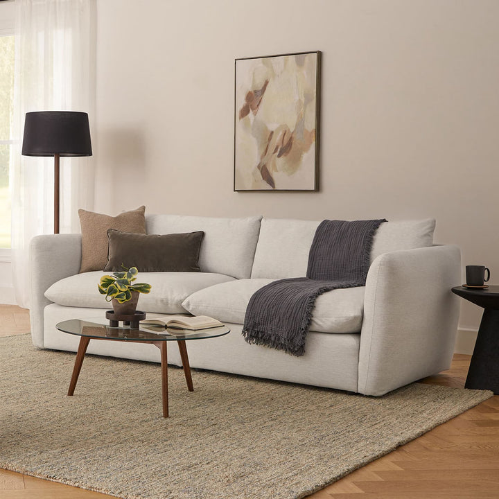 RA Glass Coffee Table with transparent tempered glass top and walnut-stained oak legs in a modern living room
