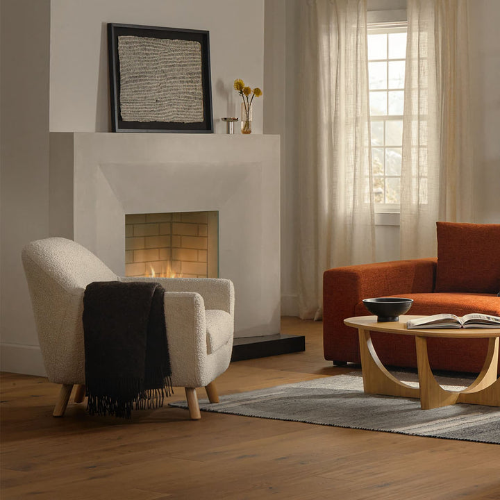 Santorini bouclé lounge chair in emerald green with curved wood frame in modern living room