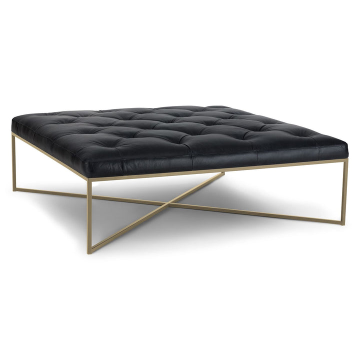 Sarek Leather Square Ottoman in an industrial-chic living room with brass legs and tufted leather