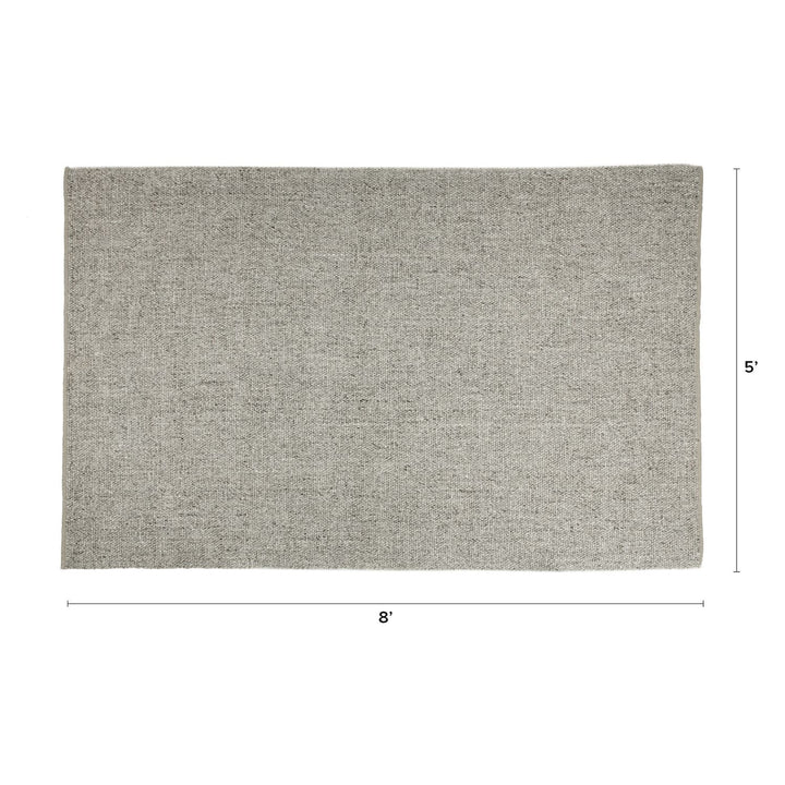 Silvanus Hand-Woven Wool Rug in a bohemian living room with wood floors and neutral decor