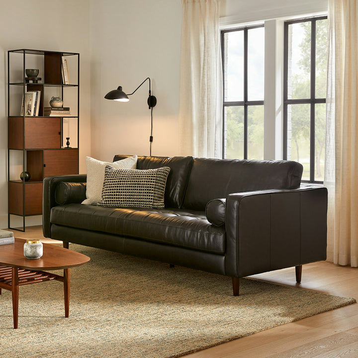 Svening Tufted Black leather sofa with bolster pillows in bohemian-style living room