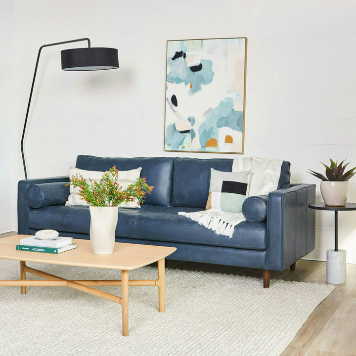 Svening Tufted Blue leather sofa with bolster pillows in bohemian-style living room