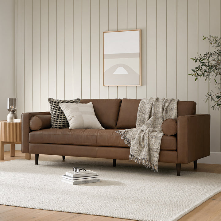 Svening Tufted Chocolat leather sofa with bolster pillows in bohemian-style living room