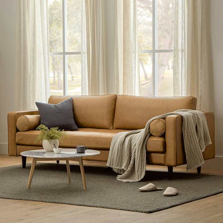 Svening Tufted Oxford Blue leather sofa with bolster pillows in bohemian-style living room