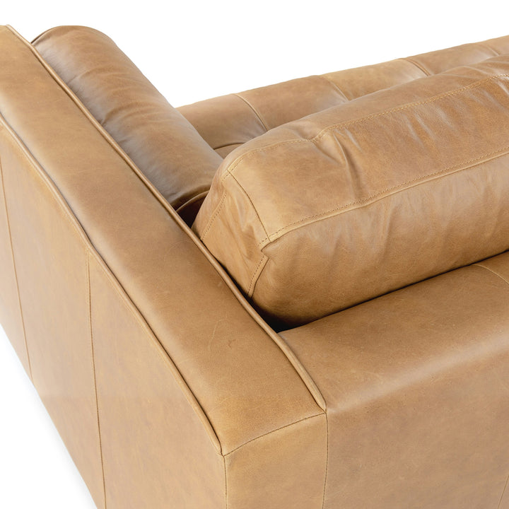 Svening Tufted Tan leather sofa with bolster pillows in bohemian-style living room