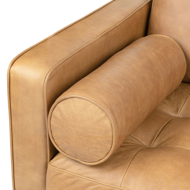 Svening Tufted Tan leather sofa with bolster pillows in bohemian-style living room