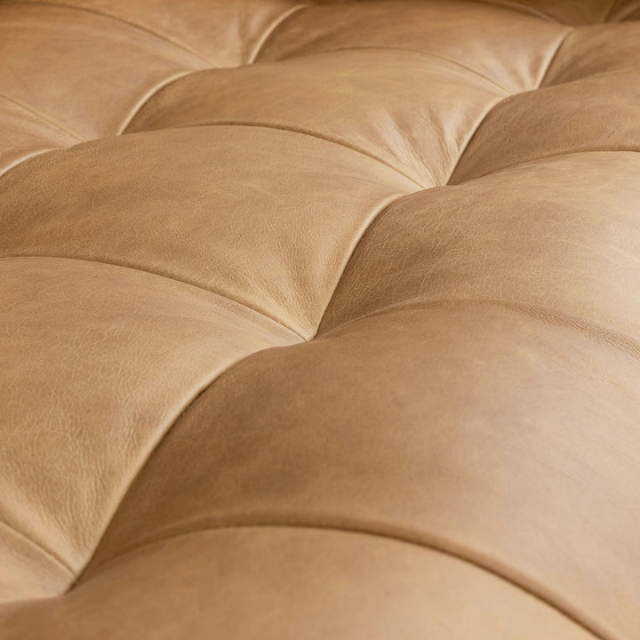 Svening Tufted Tan leather sofa with bolster pillows in bohemian-style living room