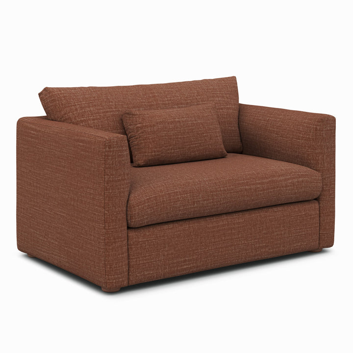 Sylph Sleeper Lounge Chair in Rust fabric, converted to bed mode in studio apartment