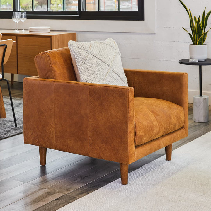 Titan Leather Lounge Chair in aged caramel leather with oak legs in industrial loft