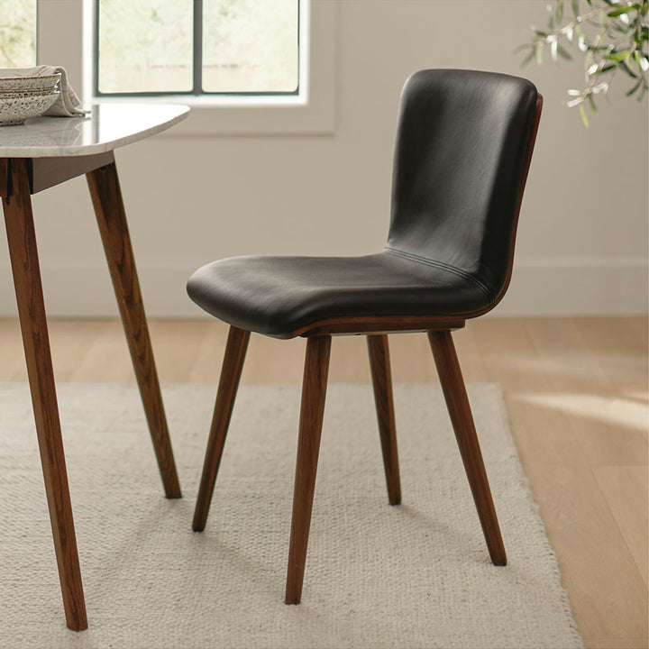 Vela Dining Chairs in a mid-century modern dining room with Toscana leather and tapered legs