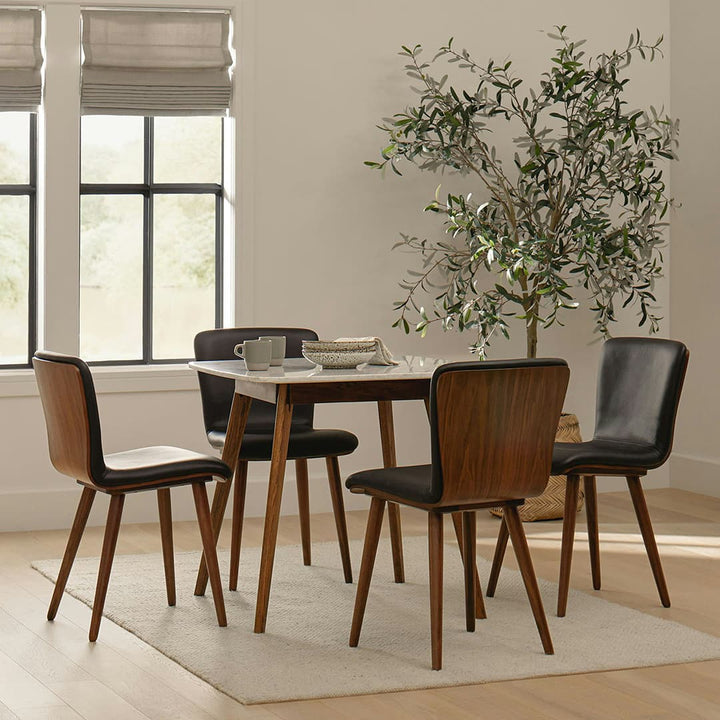 Vela Dining Chairs in a mid-century modern dining room with Toscana leather and tapered legs