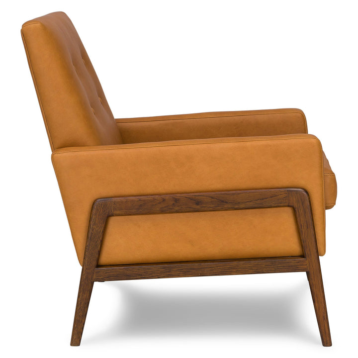 Zephyr Tan Leather Lounge Chair in aged patina beside family photo album on oak side table
