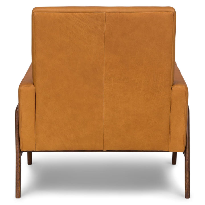 Zephyr Tan Leather Lounge Chair in aged patina beside family photo album on oak side table